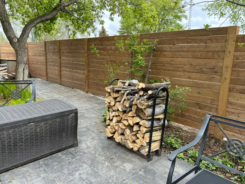 Horizontal-slat wood privacy fence around a backyard patio in Saskatoon